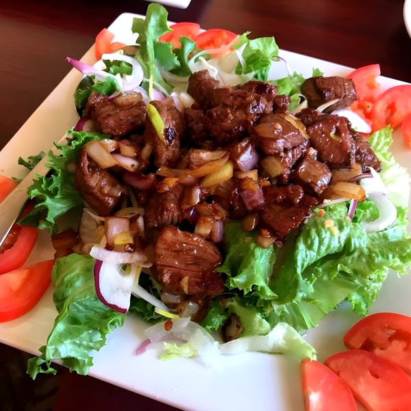 Belmarasia's Asian-fusion beef salad with lettuce, tomatoes, onions, and glazed beef pieces.